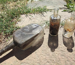 Skleněné lahve použité ke knoflíkářské výrobě. Archeologové je objevili při...