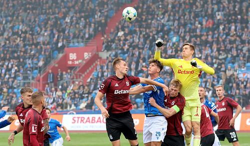Sparťanský brankář boxuje míč po rohovém kopu Baníku.