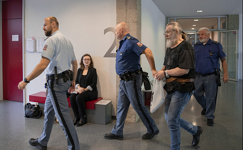 Jan Fišara přichází před soud v doprovodu policejní eskorty. (21. září 2026)