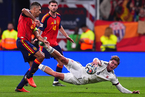 Český útočník Ryan Naderi padá v souboji s Rodrim ze Španělska.