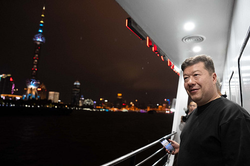 Tomio Okamura si během návštěvy Číny prohlíží noční Šanghaj z paluby lodi.