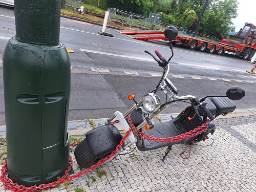 Důsledná kontrola. Policisté se chystají zkontrolovat zaparkovaný e-moped....