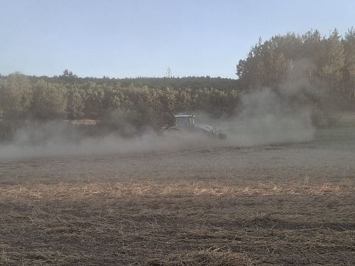 Sucho drtí zemědělce na Plzeňsku. Snímek traktoru v oblacích prachu, jenž...