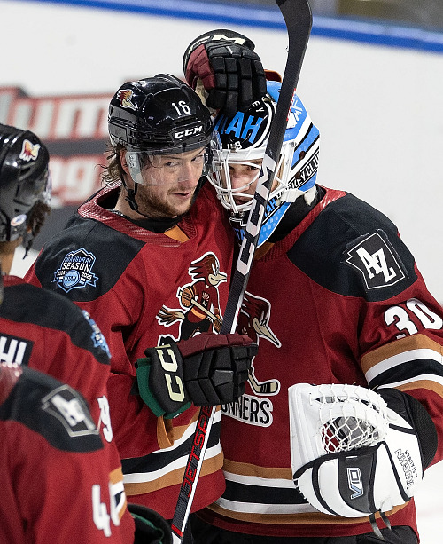 Ryan McGregor z Tucson Roadrunners gratuluje brankáři Jaxsonu Stauberovi.