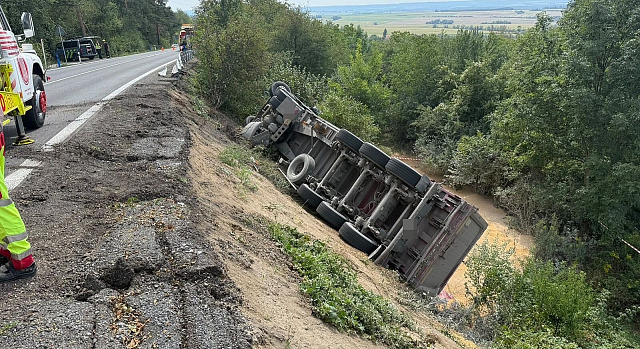 Kamion prorazil svodidla a skončil na boku ve srázu. (26. srpna 2026)