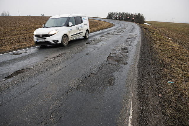 Silnice plná výtluků nedaleko Ostrovačic na Brněnsku u dálnice D1. (únor 2026)